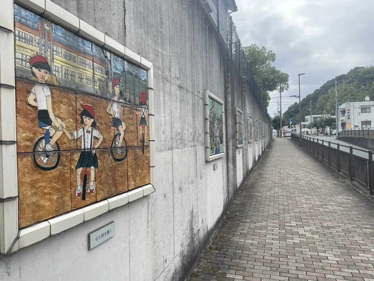 Kachelbilder an der Mauer beim Bahnhof Hamada